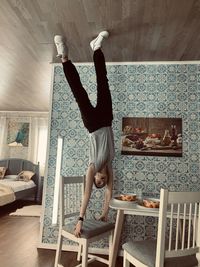Full length of man skateboarding on wall at home