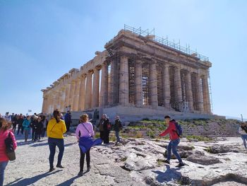 Group of people walking in front of historical building