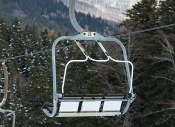 Chair lift on over the snowy forest at abetone, italy.