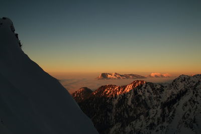 Scenic view of snowcapped mountains against sky during sunset