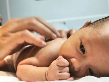 Close-up portrait of baby lying on bed