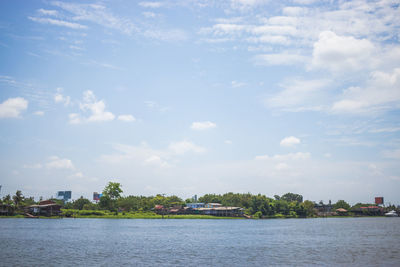 Scenic view of sea by buildings against sky