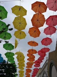 Low angle view of umbrellas hanging against sky