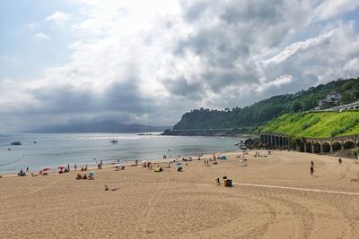 Group of people on beach against sky