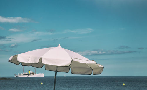 Lounge chairs on beach against sky