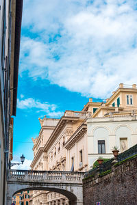 Low angle view of bridge and buildings against sky