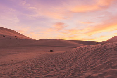 Scenic view of desert against cloudy sky