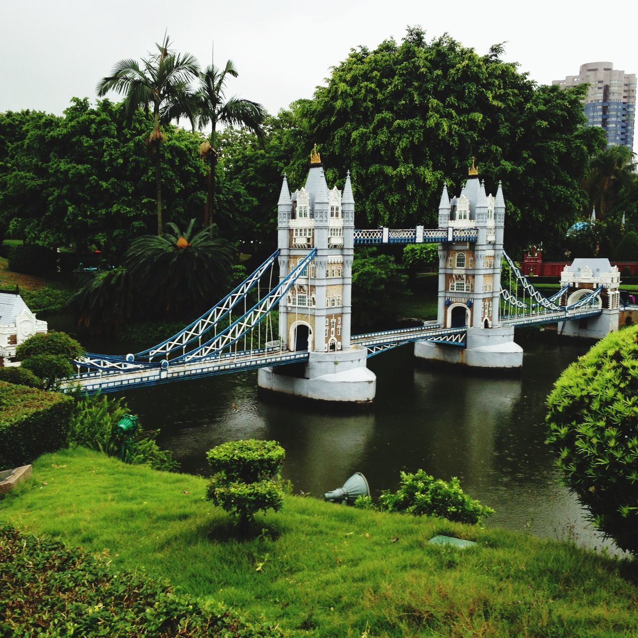 architecture, built structure, tree, building exterior, water, river, green color, famous place, travel destinations, bridge - man made structure, city, growth, reflection, connection, tourism, travel, pond, tower, history, plant