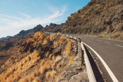 Road by mountain against sky