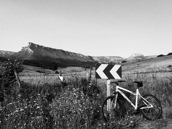 Bicycle on field against clear sky