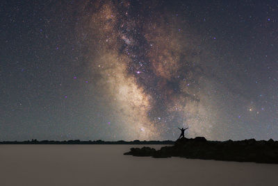 Low angle view of man standing on field against sky at night