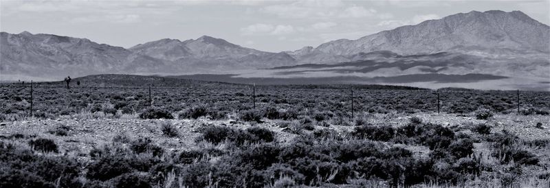 Scenic view of land and mountains against sky
