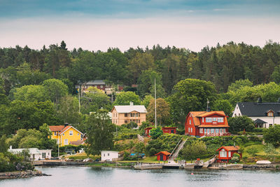 Houses by trees against sky