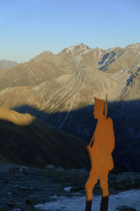 Man standing on snowcapped mountain against sky