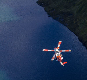 High angle view of helicopter flying over lake