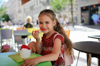 Portrait of smiling woman sitting on table at cafe