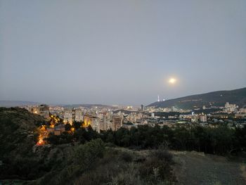 High angle view of illuminated buildings in city against clear sky