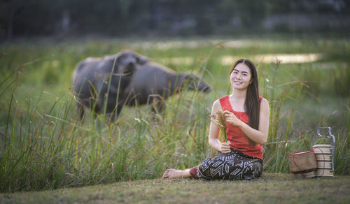 Portrait of young woman sitting on field