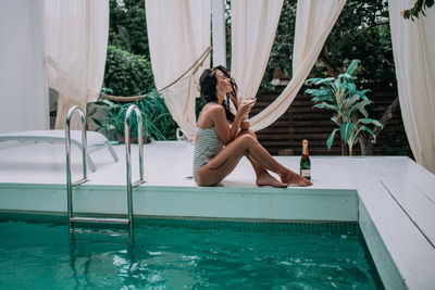 Woman sitting in swimming pool