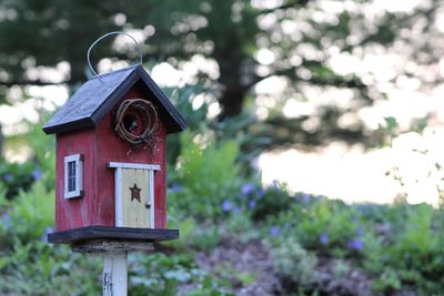 Close-up of birdhouse on wooden post