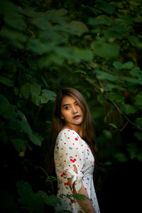 Side view of thoughtful young woman standing in forest