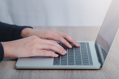 Midsection of man using laptop on table