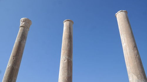 Low angle view of smoke stack against blue sky