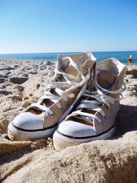 High angle view of shoes on beach against clear sky