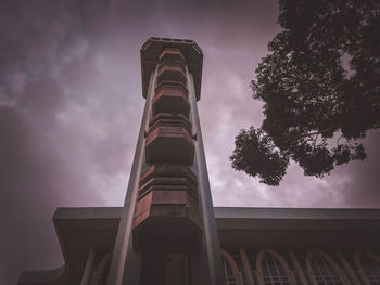 Low angle view of building against cloudy sky