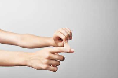 Close-up of hand holding hands over white background