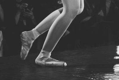 Low section of woman dancing ballet on floor