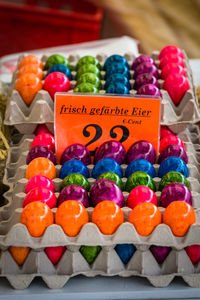 Close-up of colorful easter eggs in crate with label for sale at store