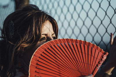 Close-up of woman holding hand fan