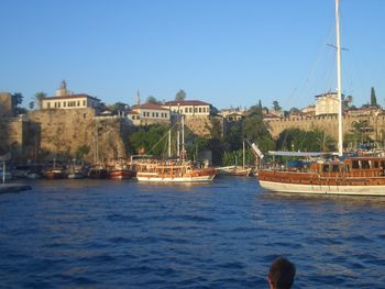 Boats in river with buildings in background