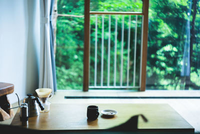 Coffee cup on table against window