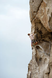 Low angle view of man climbing mountain