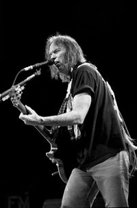 Man playing guitar against black background