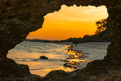 View of watamu beach at sunset through a hole in a coral rock in watamu, malindi, kenya