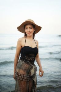 Portrait of beautiful young woman standing at beach