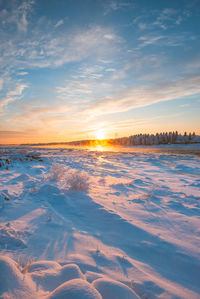 Scenic view of frozen river against sky during sunset