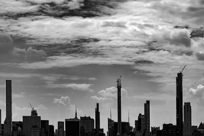 Buildings in city against cloudy sky