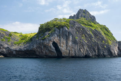 Scenic view of cliff by sea against sky