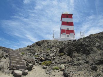 Low angle view of flag on rock against sky