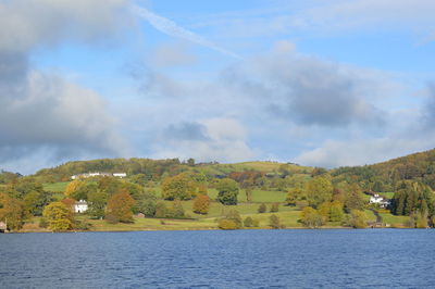 Trees on hill against cloudy sky