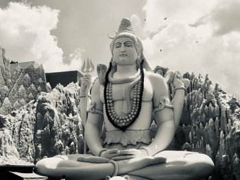 Statue of shiva against cloudy sky