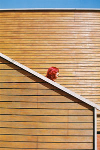 Woman head on railing against wall