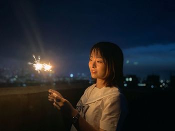 Young woman looking away against black background