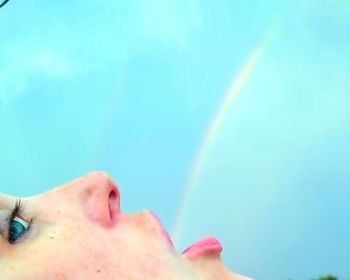 Cropped image of woman against blue sky