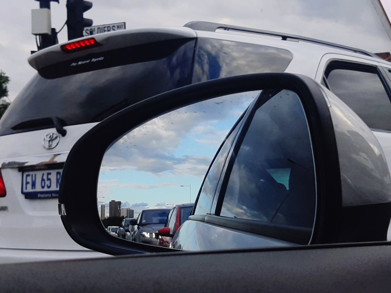CLOSE-UP OF SIDE-VIEW MIRROR OF CAR