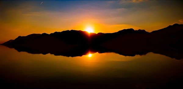 Scenic view of silhouette mountains against sky during sunset